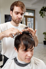 Barber talking to caucasian man while sitting in chair