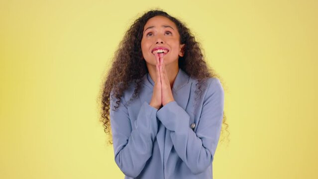 Anxiety, hope and black woman with hands for prayer hopeful for success, winning and good news. Emoji, anxious and face of isolated girl with palms together praying for opportunity in yellow studio
