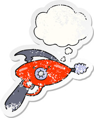 cartoon ray gun and thought bubble as a distressed worn sticker