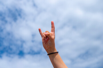 hand of a girl making the sign of horns with her fingers