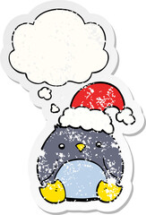 cute cartoon penguin wearing christmas hat and thought bubble as a distressed worn sticker