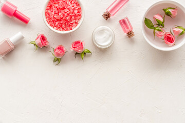 Pink roses cosmetic products set with flowers essential oil. Beauty care concept.