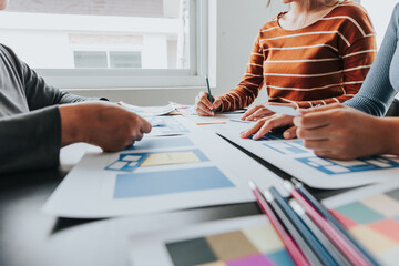 Close up ux developer and ui designer brainstorming about mobile app interface wireframe design on...