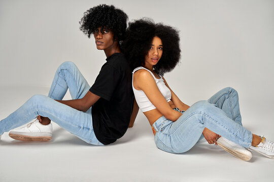 Photo of young african american couple with afro hairstyle isolated on gray background