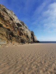 cliff coast in portugal with blue sky ocean and sand beach