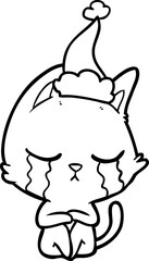Obraz premium crying line drawing of a cat sitting wearing santa hat