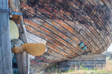 An old abandoned wooden shipwreck with a copper propeller. Wooden planks from old retro hull boat.