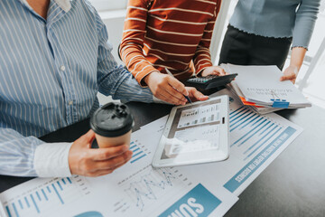Team of business people meeting to explain financial graph data and marketing plan Group of business people at a meeting assessing the status of business investment and marketing