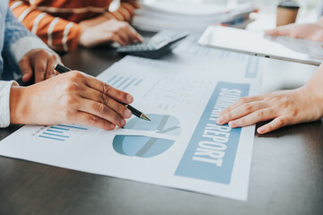 Team of business people meeting to explain financial graph data and marketing plan Group of business people at a meeting assessing the status of business investment and marketing