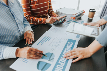 Team of business people meeting to explain financial graph data and marketing plan Group of business people at a meeting assessing the status of business investment and marketing