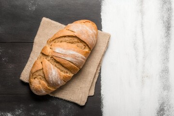 perfect bread to accompany your healthy meals on a brown wooden table with part covered in flour