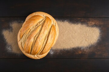bread on wooden board, freshly baked rustic sourdough bread dusted with powdered sugar