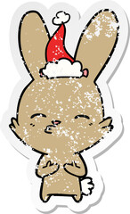 curious bunny distressed sticker cartoon of a wearing santa hat
