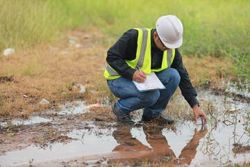Environmental engineers work at water source to check for contaminants  in water sources and analysing water test results for reuse.World environment day concept.