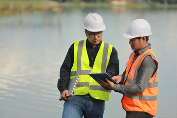 Environmental engineers work at water source to check for contaminants  in water sources and analysing water test results for reuse.World environment day concept.