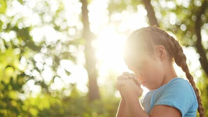 child pray. young gratitude a god religion concept. little girl in lifestyle nature outdoors praying dreams of happiness to god. praise worship freedom concept. kid praying in the forest