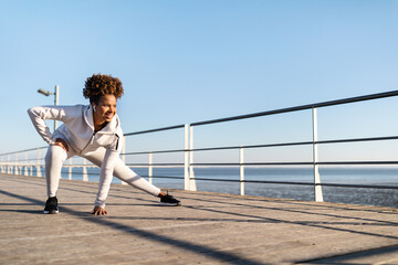 Sporty Young Black Woman Exercising On Wooden Pier Near Sea