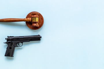 Hand gun weapon and judges gavel - gun law. Illegal use of weapons concept