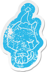 crying cartoon distressed sticker of a cat sitting wearing santa hat