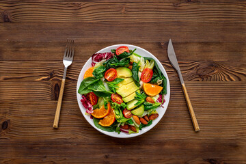 Healthy vegetarian bowl - green salad with avocado and tomatoes