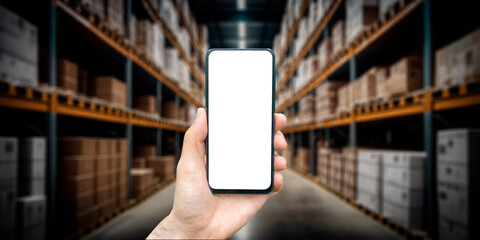 Warehouse with a hand holding an empty smartphone. Blurred industrial warehouse with goods and...