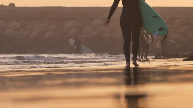 Silhouettes of Surfers Walking on Atlantic Ocean Coast at Sunset in Morocco