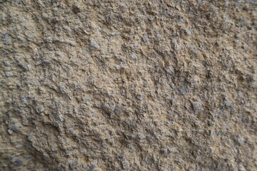Textured rough grey stone wall of concrete close up