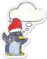 cute cartoon christmas penguin and thought bubble as a distressed worn sticker