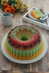 colorful pudding filled with kiwi and strawberry pieces on a white plate