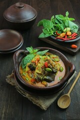 cooking fish with curry sauce and cayenne pepper in a clay dish