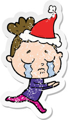 distressed sticker cartoon of a crying woman wearing santa hat