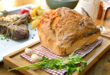 Fototapeta na wymiar Homemade bread with parsley and T-bone steak in the background.