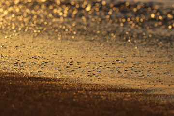 Fototapeta na wymiar Brillos y texturas en la orilla del mar al amanecer