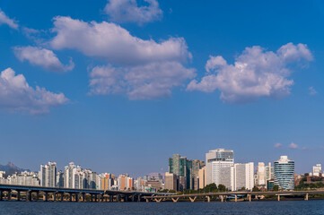 Fototapeta premium Seoul cityscapes, skyline, high rise office buildings and skyscrapers in Seoul city, winter daylight, top view in winter, Seoul, Republic of Korea, in mist winter season with blue sky and cloud