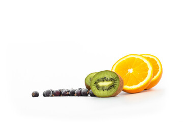 Kiwi, orange and black currants on light background