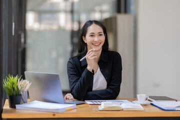 Fototapeta premium Portrait of business asian woman working on laptop in her workplace. asian smile business lady employee working on laptop in office finance business concept.
