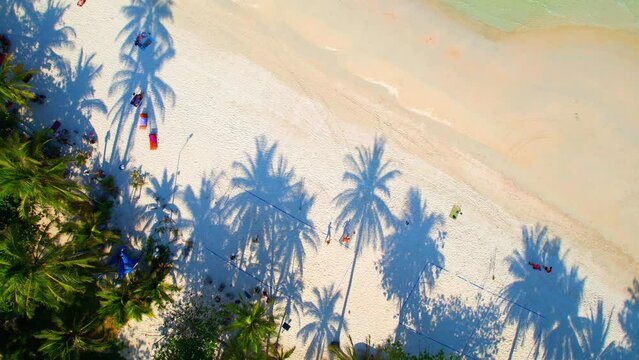 From an aerial perspective drone, you can see the long stretches of white sand that line the coast, with crowds of people gathered on the beach. (Haad Rin, Koh Phangan, Thailand). tropical concept
