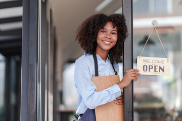 Female store owner or staff, food, cafe or bar, showing the OPEN sign with a welcome smile, welcome.