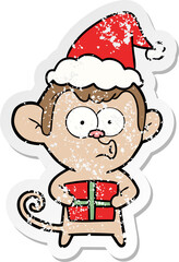 distressed sticker cartoon of a christmas monkey wearing santa hat