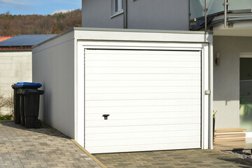 Moderne Beton-Garage mit Automatik-Tor in der Hauszufahrt