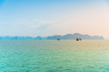 View of Ha Long Bay; with a lot of limestone islets and cruise ships; on a blue sky summer day.