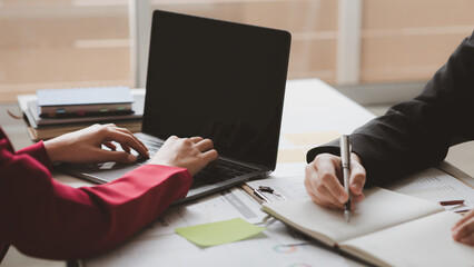 Fototapeta premium Two businessmen are brainstorming together and reviewing the company financial documents that the finance department has summarized, they are business partners. Business administration concept.
