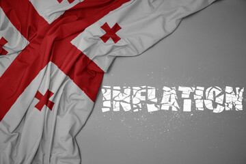 waving colorful national flag of georgia on a gray background with broken text inflation. 3d illustration