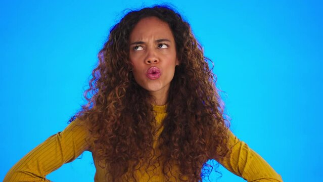 Woman, funny face and playful with goofy expression and hand gesture isolated on blue background. Comic, silly and carefree young female in studio, laughing and comedy with freedom and happiness