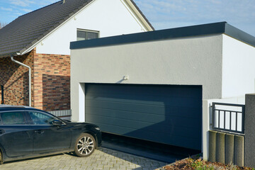 Moderne Beton-Garage mit Automatik-Tor in der Hauszufahrt