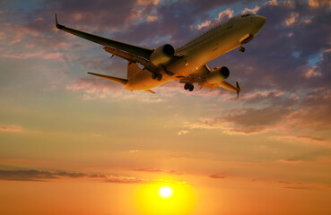 Fototapeta na wymiar Plane in sky during sunset, low angle view