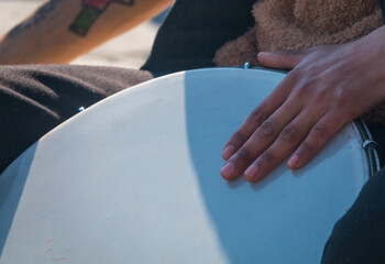 A Gipsy street musician plays the tambourine or Turkish drum with fast rhythms on the streets of...