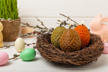 Easter eggs candles. easter bunny and willow branches on white texture background. Easter holiday concept. Spring bouquet of willow. Decor for home and holiday table. Copy space. Place for text.
