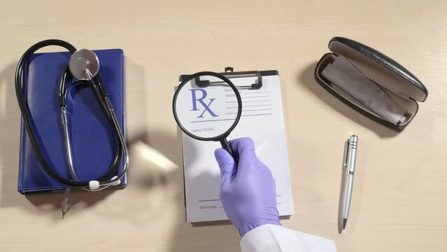 Hand in purple rubber glove takes magnifying glass, goes along empty prescription, turns to next page, focuses on words time to rest, stethoscope, spectacle case, pen. Close up, 4K Ultra HD.