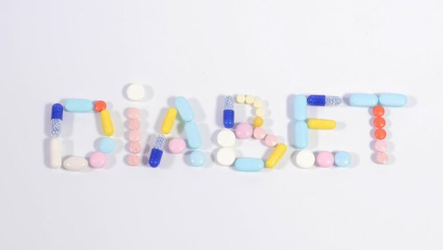 Multicolored tablets, pills and capsules make word diabet on white background. Concept of dietary supplements, vitamins, microelements, wellbeing. Stop motion animation.
